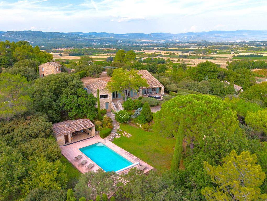Proche Gordes, cette maison en pierres avec maison d’amis, situation exceptionnelle et vues panoramiques sur le Luberon, le village de Goult et Roussillon.