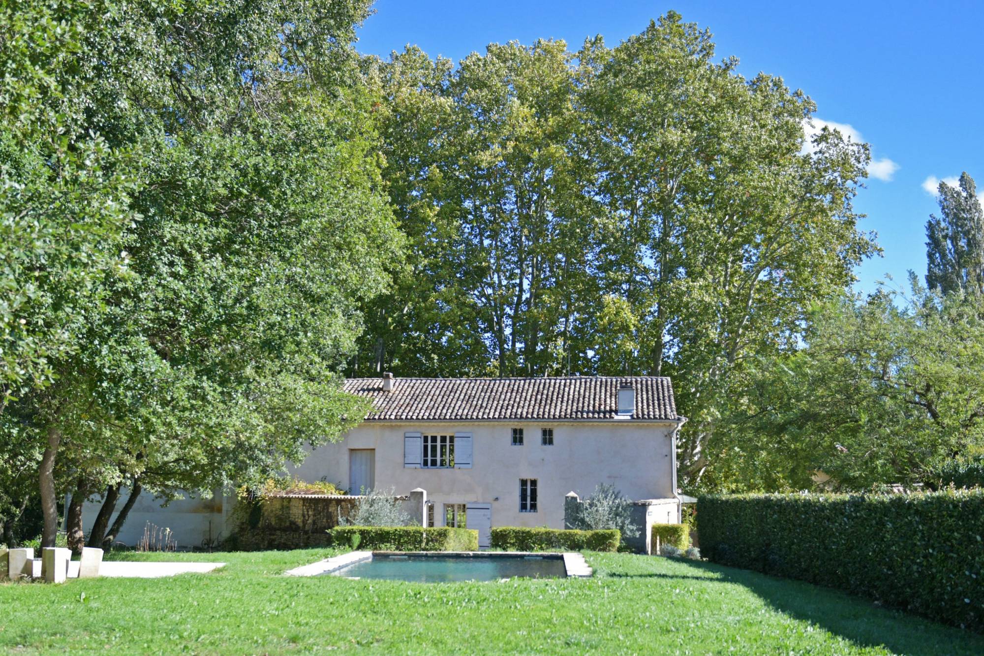 Élégant moulin du XVIe rénové en bastide provençale avec piscine, et parc arboré au cœur du Luberon.