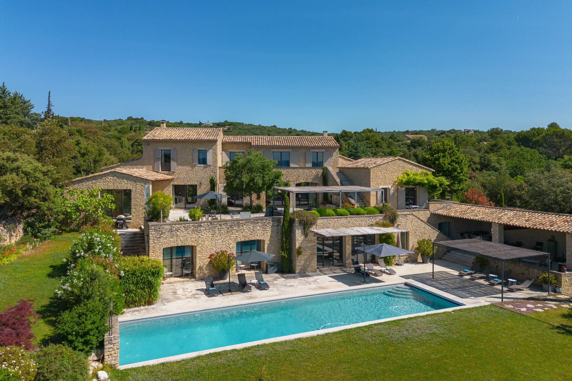 Propriété contemporaine en pierre à vendre, sur les hauteurs de Gordes, au cœur d’un hectare paysager avec vue panoramique sur le Luberon.
