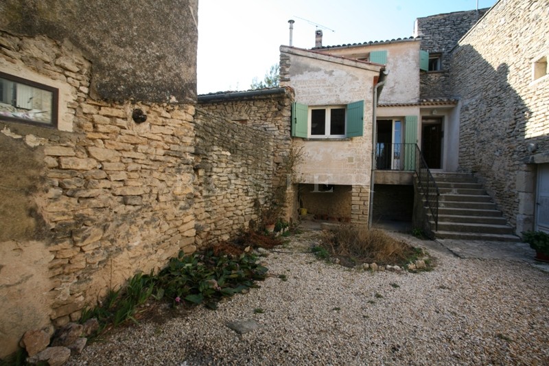 Proche Gordes, dans un charmant village du Luberon, à vendre, maison avec cour. Nombreuses Possibilités.  