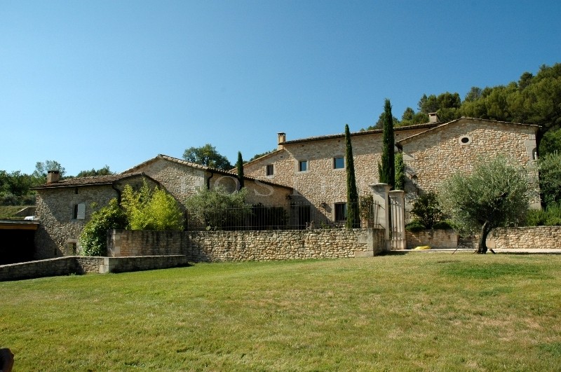 A quelques minutes du village de Gordes, en position dominante et bénéficiant de vues sur le Luberon et les Alpilles, maison de charme en pierres totalement rénovée à vendre,  propriété très haut de gamme, 3.000 m² environ de bâtis couverts, sur 33 hec