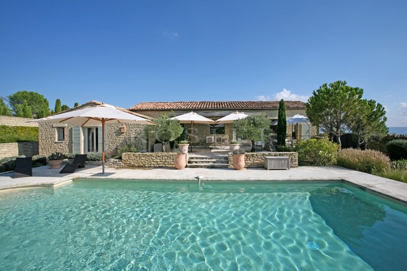 Aux abords d'un célèbre village perché du Luberon,  Gordes, à vendre, superbe maison en pierres avec terrasses et piscine.   