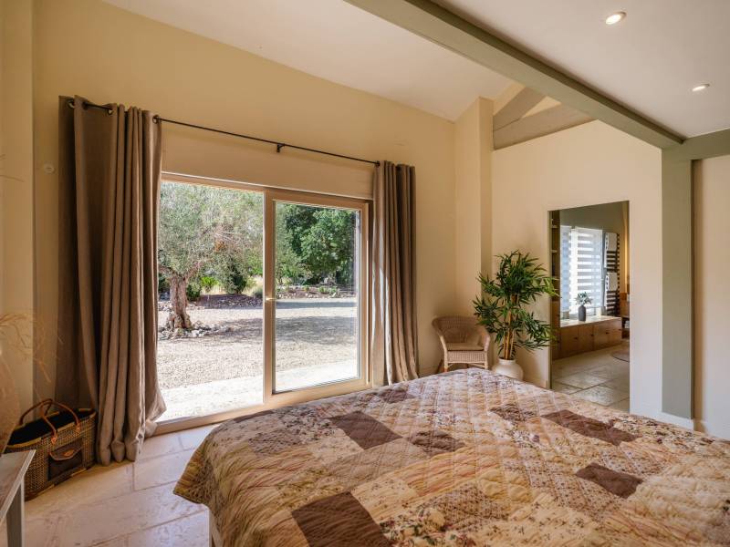 Suite parentale de plain-pied : Chambre lumineuse en rez-de-chaussée s'ouvrant largement sur le jardin et la nature environnante.