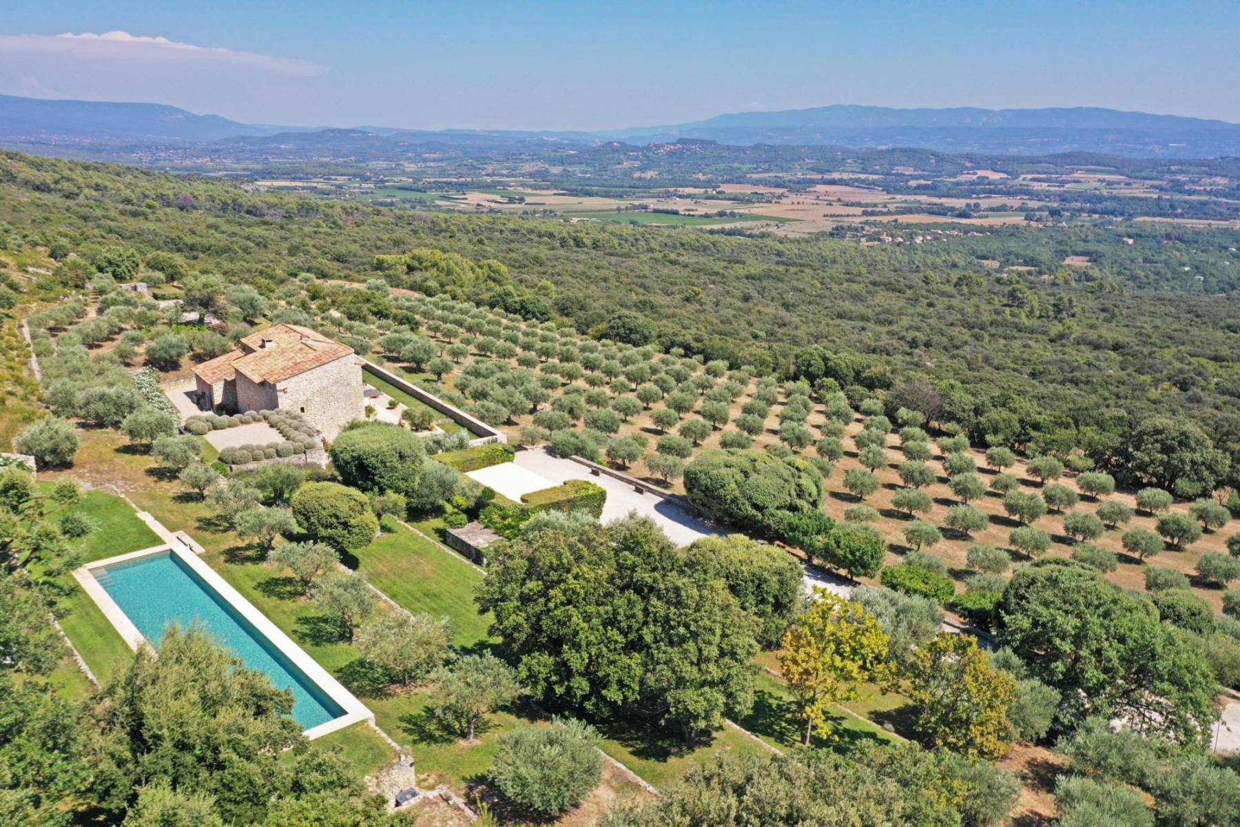 En exclusivité - authentique ferme à la rénovation contemporaine sur 6 hectares en situation extraordinaire à Gordes face à la vallée du Luberon.