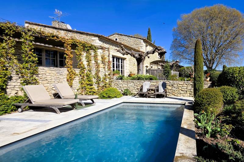 A Gordes, élégante maison de hameau en pierres restaurée avec terrasses, piscine et vue sur le Luberon.