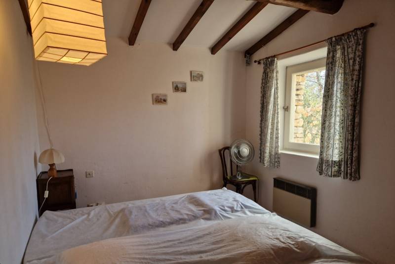 A vendre au pied du village de Gordes, charmante maison en pierres avec piscine dans un environnement agricole et bordée de bois.