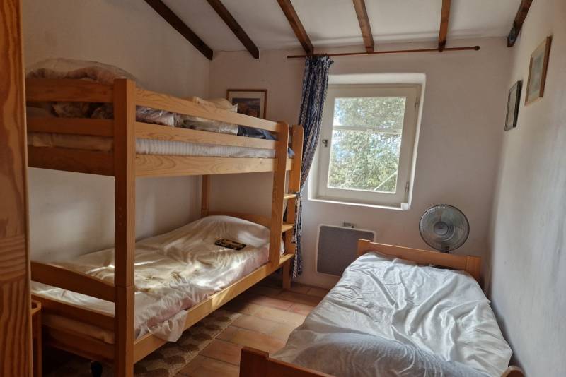 A vendre au pied du village de Gordes, charmante maison en pierres avec piscine dans un environnement agricole et bordée de bois.