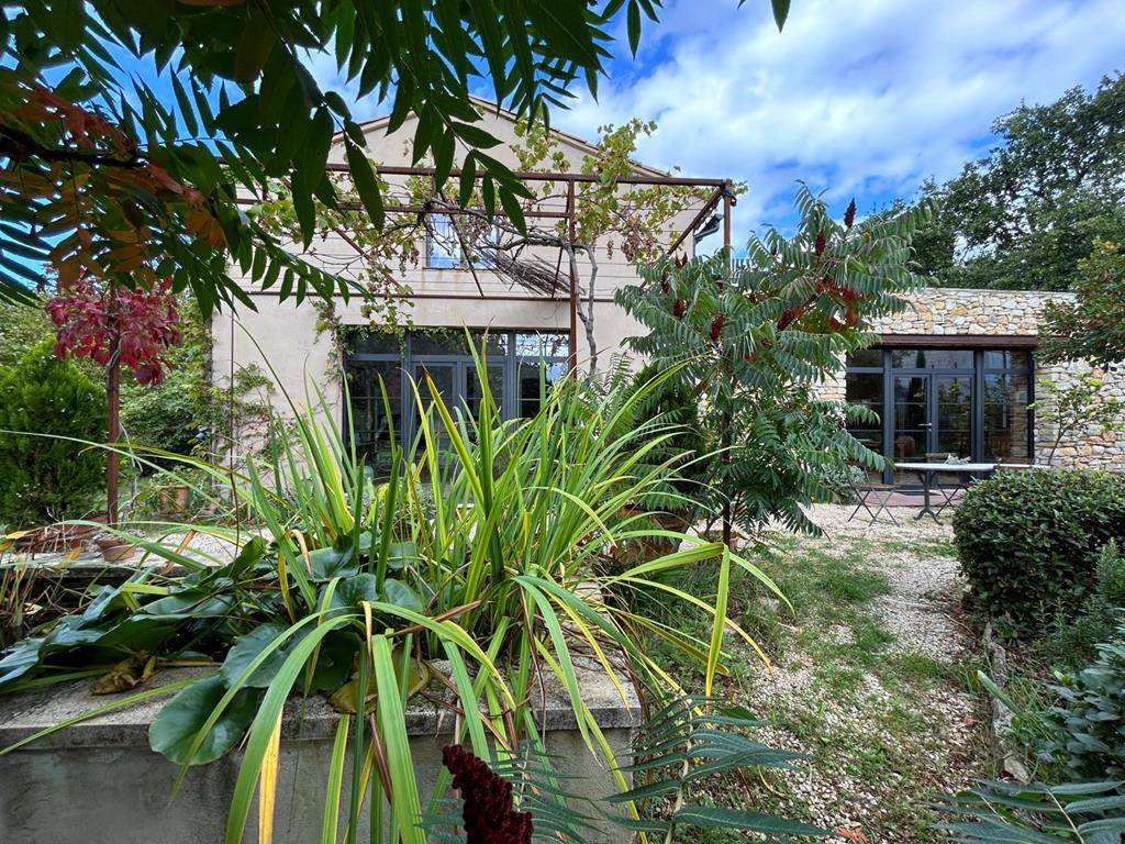 Maison de charme aux lignes contemporaines avec jardin luxuriant et bassin   