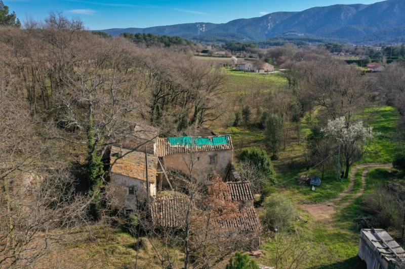 À quelques minutes des villages emblématiques du Luberon, dans le village d'Oppède, authentique ferme en U à rénover.