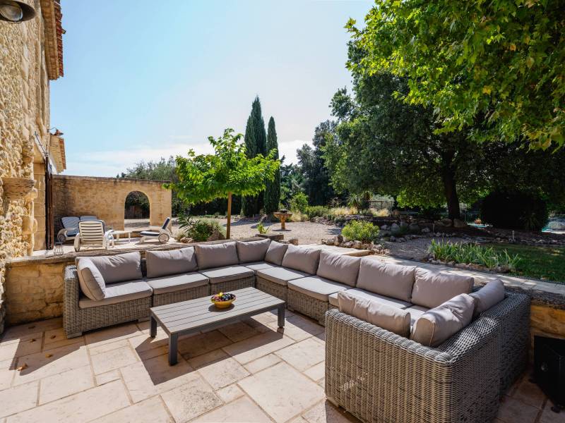Convivialité et détente : Terrasse aménagée avec salons de jardin extérieurs, bordée par un terrain paysager de 2 835 m².