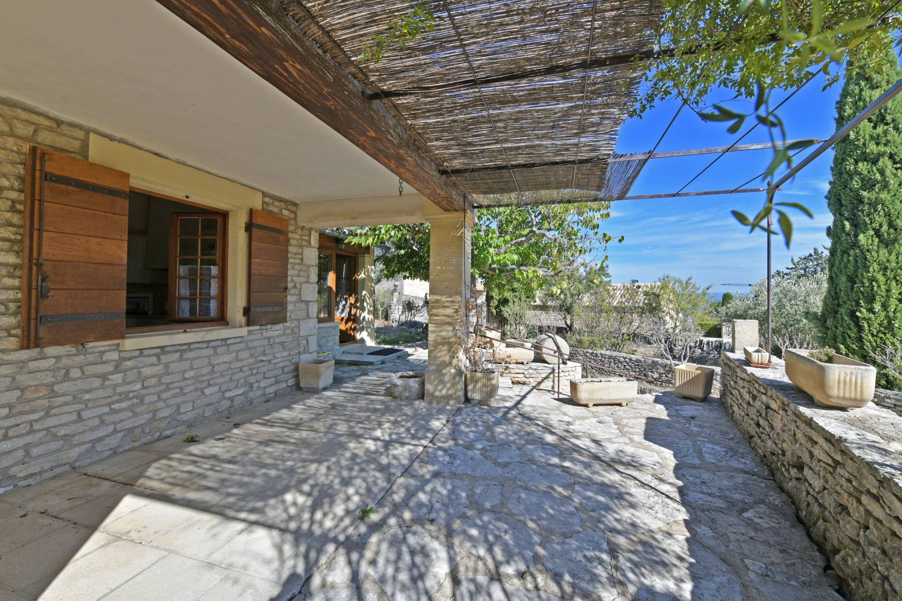 Gordes : Maison en pierres avec moulin et borie au centre du village   