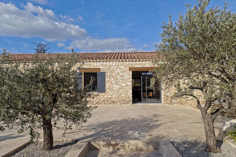 A la vente à Gordes, maison de plain-pied en pierre avec piscine et garage dans quartier résidentiel calme.