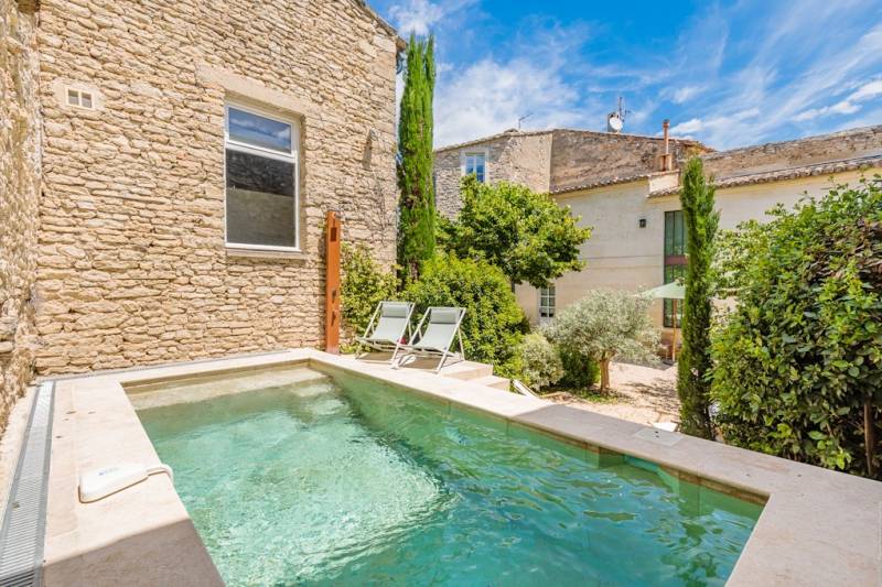 À Gordes, au cœur d’un hameau prisé, superbe maison en pierre du XVIIIe restaurée avec deux annexes dans un jardin clos avec bassin.