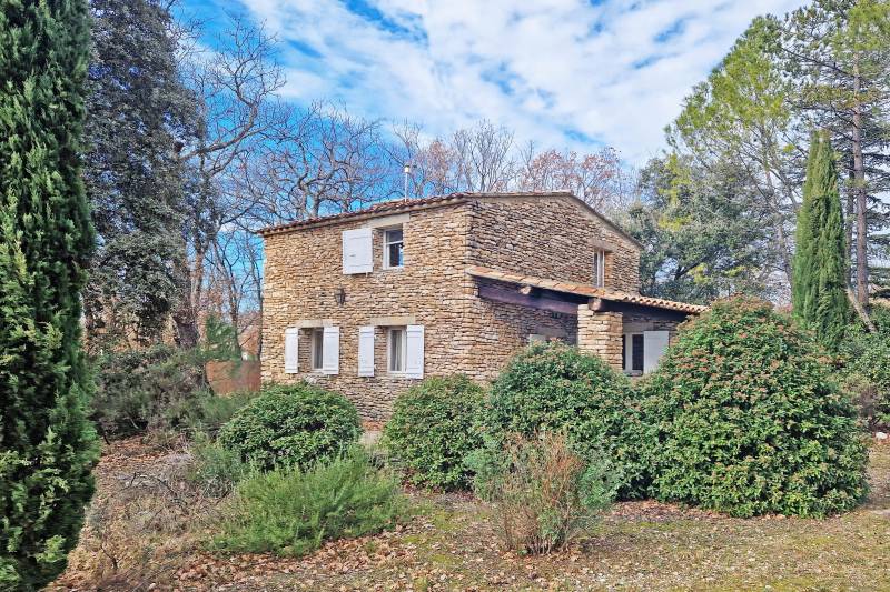 A vendre au pied du village de Gordes, charmante maison en pierres avec piscine dans un environnement agricole et bordée de bois.