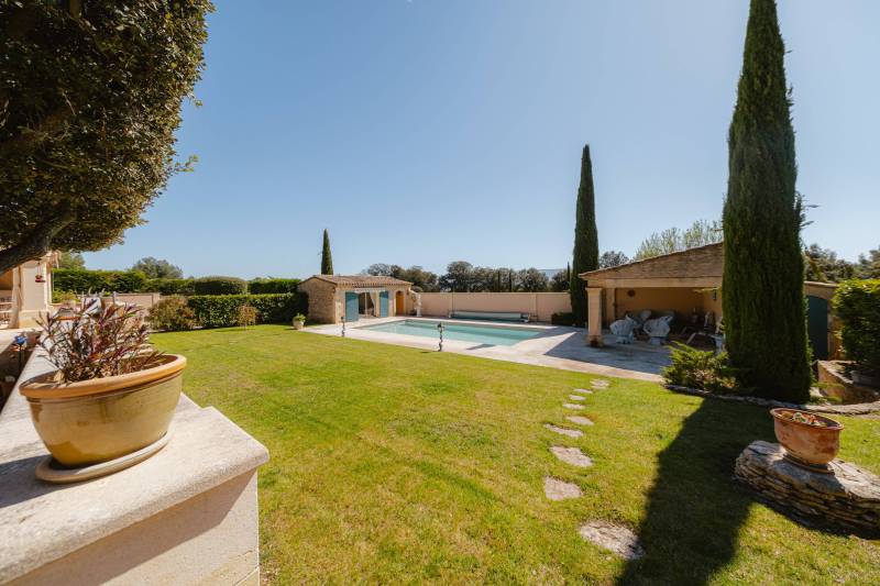 Entre Gordes et Cabrières d'Avignon, face au Luberon et ses villages perchés, propriété en pierres avec piscine chauffée, pool house et dépendances à vendre en Provence.