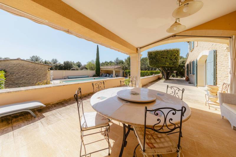 Entre Gordes et Cabrières d'Avignon, face au Luberon et ses villages perchés, propriété en pierres avec piscine chauffée, pool house et dépendances à vendre en Provence.