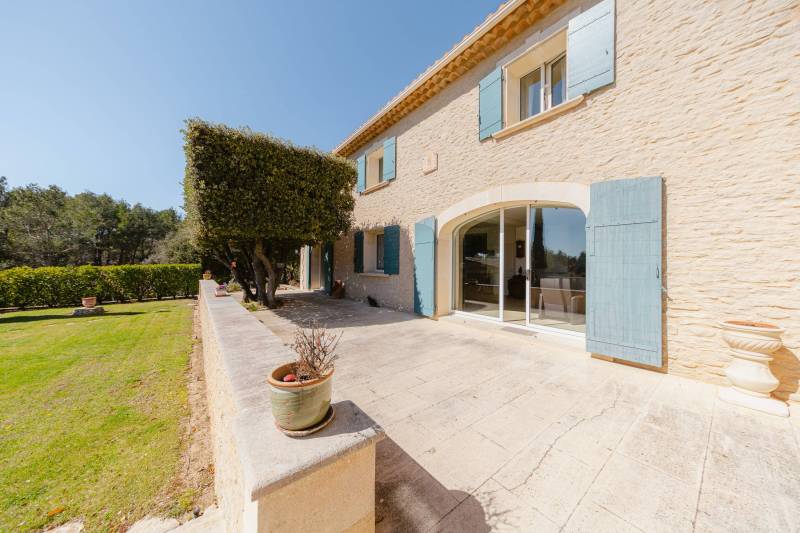 Entre Gordes et Cabrières d'Avignon, face au Luberon et ses villages perchés, propriété en pierres avec piscine chauffée, pool house et dépendances à vendre en Provence.