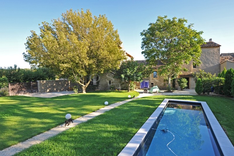 Près de Gordes,  à vendre, authentique mas provençal rénové dans un style contemporain avec jardin paysager, bassin de nage et cour intérieure. 