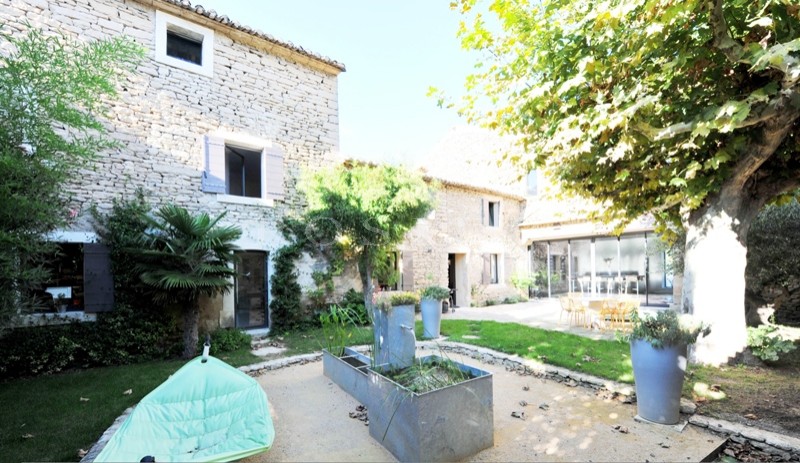 Près de Gordes,  à vendre, authentique mas provençal rénové dans un style contemporain avec jardin paysager, bassin de nage et cour intérieure. 