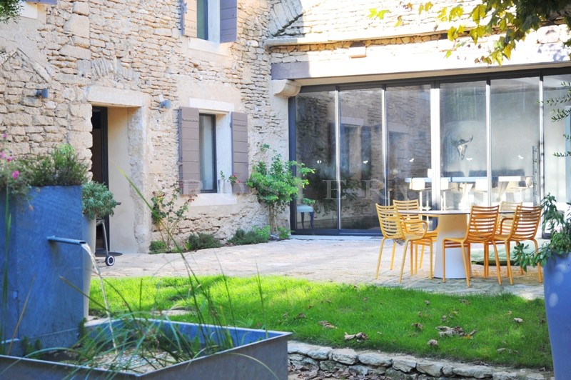 Près de Gordes,  à vendre, authentique mas provençal rénové dans un style contemporain avec jardin paysager, bassin de nage et cour intérieure. 
