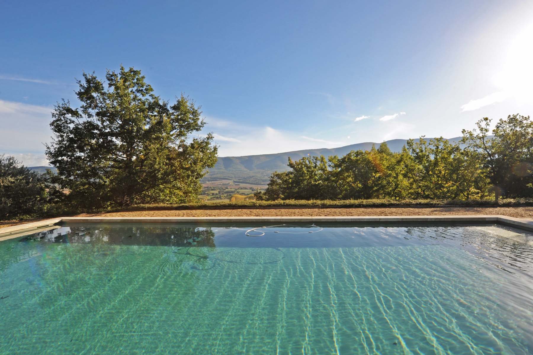 Piscine avec vue panoramique sur le Luberon dans propriété de prestige en pierre de Gordes à vendre