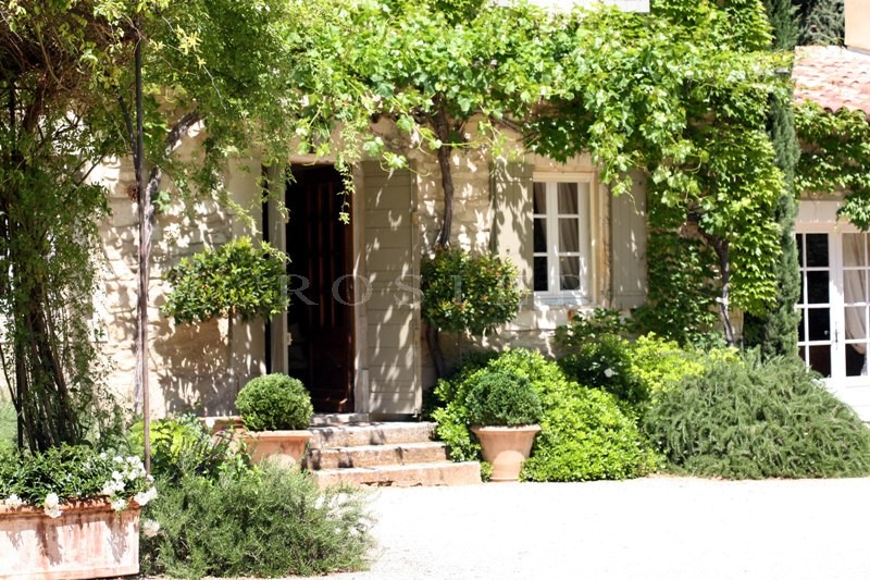 Luberon, for sale, beautiful stone farmhouse on the slope of a hill in a landscaped park with a swimming pool.