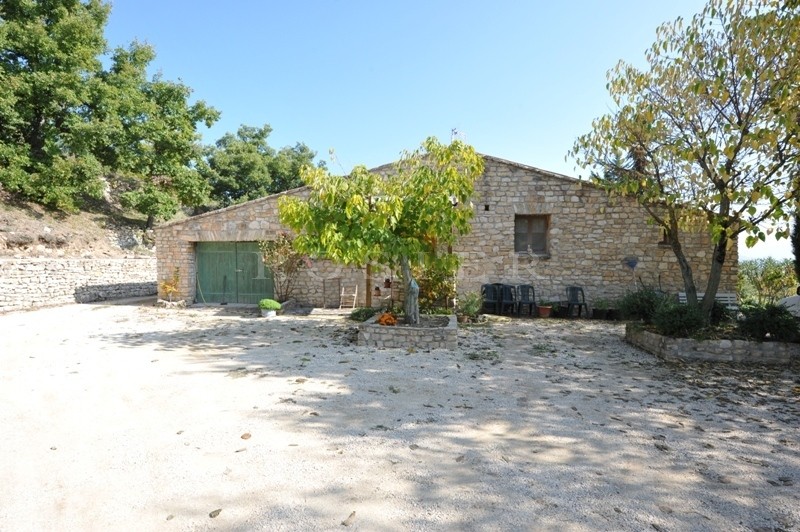 In a high position, facing the Luberon, for sale, stone built one storey property with a hectare of land
