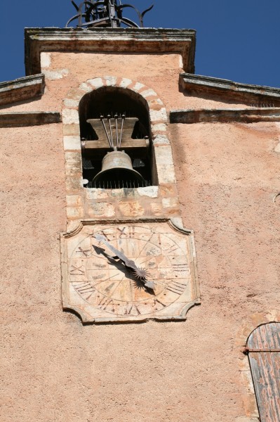 Cloche et cadran solaire sur une des portes dans le vieux village de Roussillon